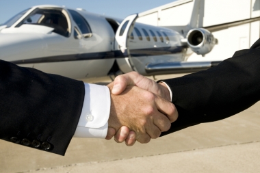 Businessmen shaking hands in front of corporate jet on (Tayhutch © Tayhutch; VisaPro.ca. All Rights Reserved.)